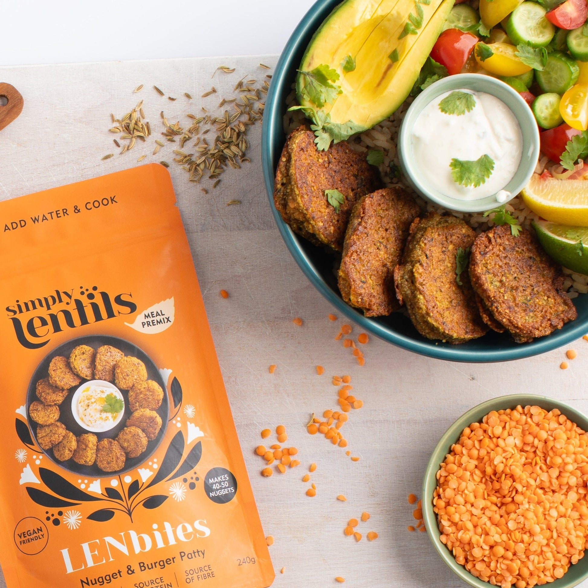 Packaging of 'Simply Lentils Nugget and Burger Patty premix with a bowl of salad and lentil nuggets on a marble board.